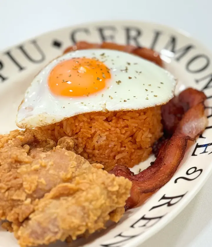 American fried rice with fried egg, crispy chicken and bacon